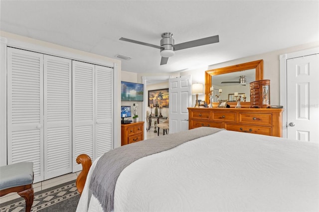 bedroom with a closet, tile patterned floors, and ceiling fan