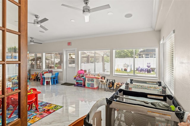 playroom featuring marble tiled floors, a ceiling fan, and crown molding