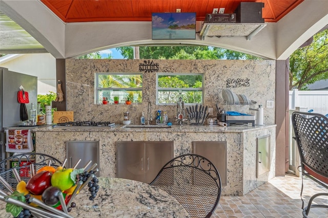 view of patio / terrace with an outdoor kitchen and fence