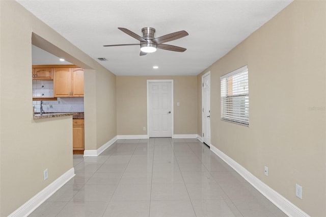 unfurnished room featuring ceiling fan, light tile patterned floors, baseboards, recessed lighting, and a sink