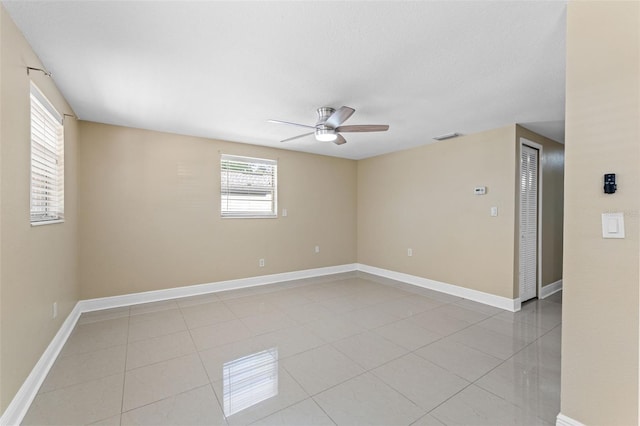 unfurnished room featuring a ceiling fan, healthy amount of natural light, and light tile patterned floors