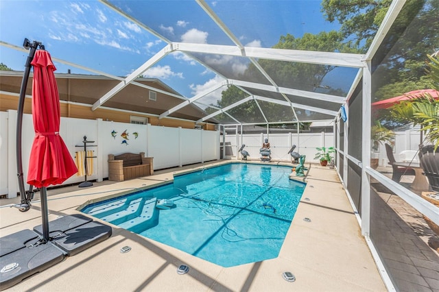 view of swimming pool featuring a fenced backyard, a patio area, and glass enclosure