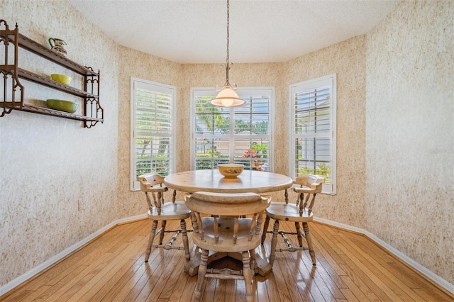 1053 Winding Willow Dr, Trinity, FL 34655 - dining space with wallpapered walls, light wood finished floors, and baseboards