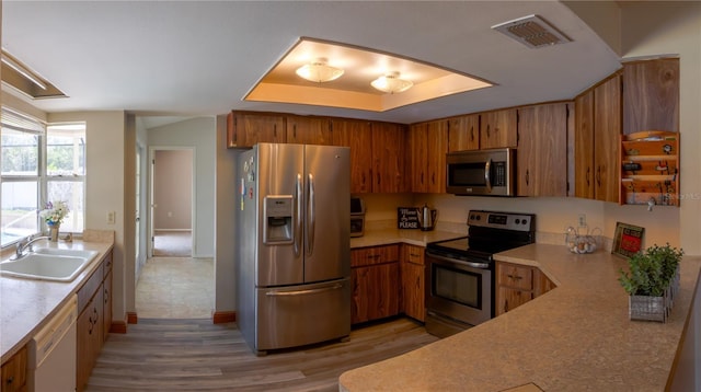 8126 Wooden Dr, Spring Hill, FL 34606 - kitchen with stainless steel appliances, a sink, brown cabinets, and light wood-style flooring