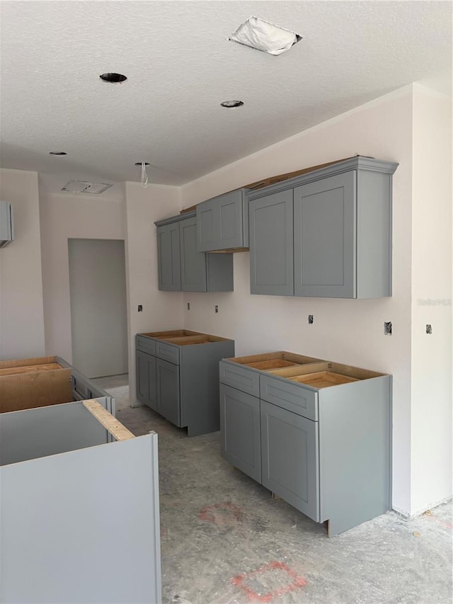 7583 St Andrews Blvd, Weeki Wachee, FL 34613 - kitchen featuring gray cabinetry and a textured ceiling
