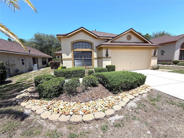 9311 Haas Dr, Hudson, FL 34669 - view of front of property featuring stucco siding, concrete driveway, an attached garage, and central AC unit