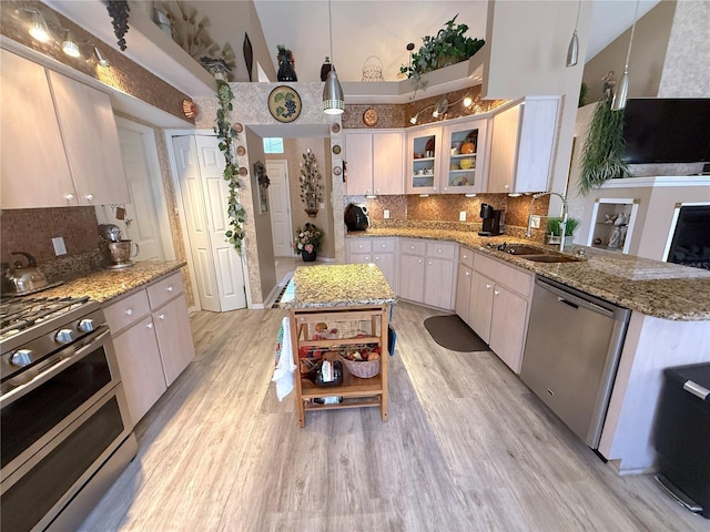 9311 Haas Dr, Hudson, FL 34669 - kitchen with stainless steel appliances, a sink, a high ceiling, backsplash, and open shelves
