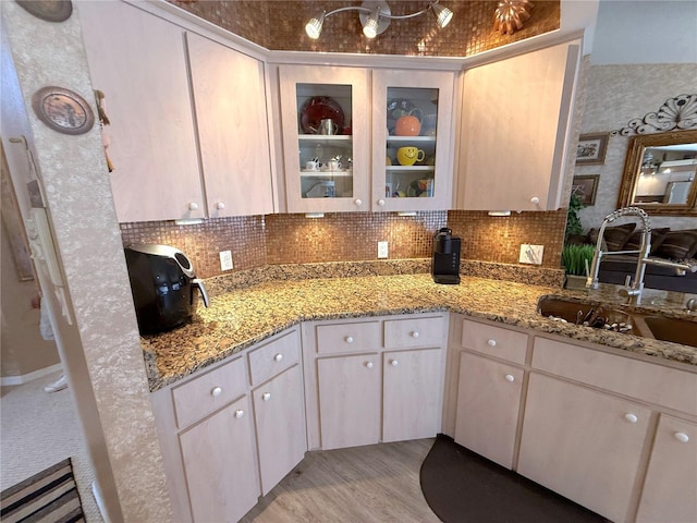 9311 Haas Dr, Hudson, FL 34669 - kitchen with a sink, tasteful backsplash, glass insert cabinets, and light stone countertops