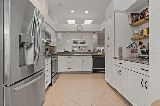2026 Golfview Dr Unit 2026, Tarpon Springs, FL 34689 - kitchen featuring appliances with stainless steel finishes, a sink, light tile patterned floors, a skylight, and white cabinetry