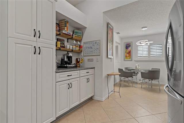 2026 Golfview Dr Unit 2026, Tarpon Springs, FL 34689 - bar area featuring freestanding refrigerator, light tile patterned flooring, baseboards, a textured ceiling, and pendant lighting