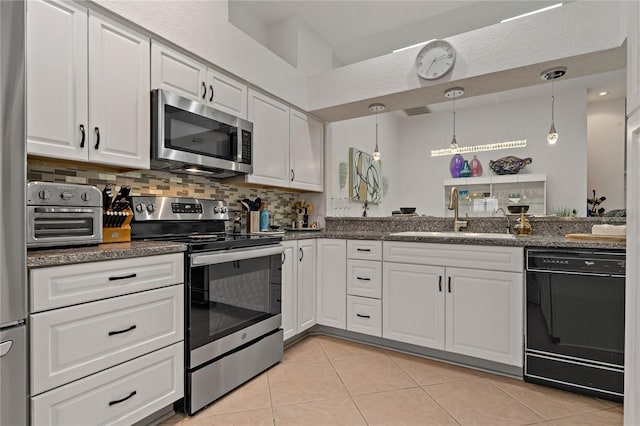 2026 Golfview Dr Unit 2026, Tarpon Springs, FL 34689 - kitchen featuring appliances with stainless steel finishes, a sink, light tile patterned floors, white cabinets, and tasteful backsplash