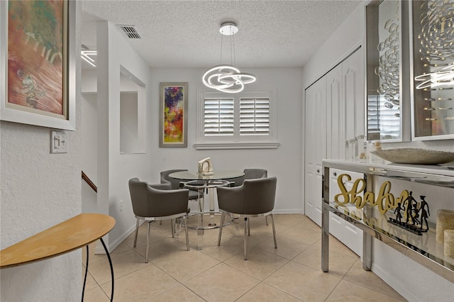 2026 Golfview Dr Unit 2026, Tarpon Springs, FL 34689 - dining space featuring a chandelier, a textured ceiling, light tile patterned flooring, and baseboards