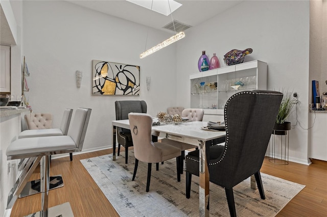 2026 Golfview Dr Unit 2026, Tarpon Springs, FL 34689 - dining area featuring a skylight, light wood-style flooring, and baseboards