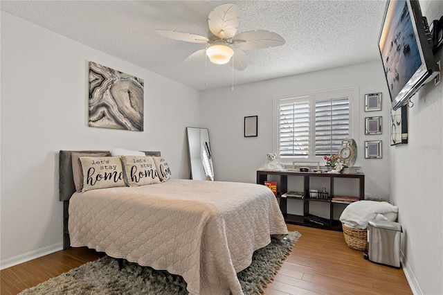 2026 Golfview Dr Unit 2026, Tarpon Springs, FL 34689 - bedroom featuring wood finished floors, a textured ceiling, baseboards, and a ceiling fan