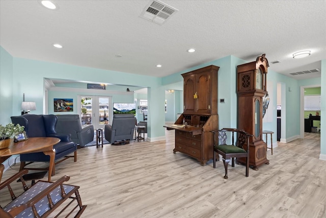 living room featuring light wood finished floors, baseboards, french doors, recessed lighting, and a textured ceiling
