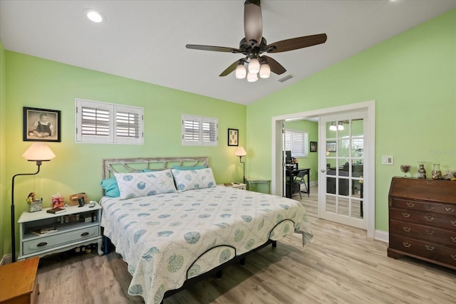 bedroom with vaulted ceiling, multiple windows, wood finished floors, baseboards, and access to outside