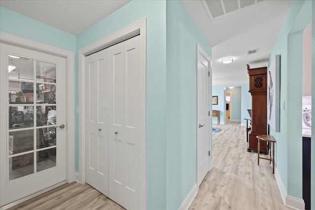foyer entrance with light wood-style floors and baseboards