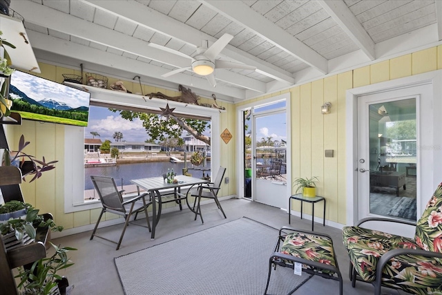 sunroom / solarium featuring healthy amount of natural light, a ceiling fan, beamed ceiling, wooden ceiling, and outdoor dining space