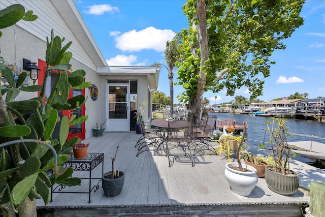 wooden deck featuring a water view and outdoor dining space