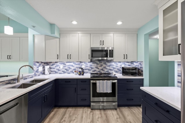 4918 Forecastle Dr, New Port Richey, FL 34652 - kitchen with stainless steel appliances, white cabinetry, backsplash, light wood-style floors, and recessed lighting