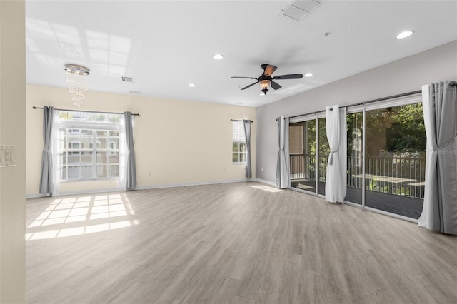 empty room with plenty of natural light, wood finished floors, baseboards, a ceiling fan, and recessed lighting
