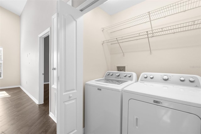 laundry area with separate washer and dryer, dark wood-style flooring, and baseboards