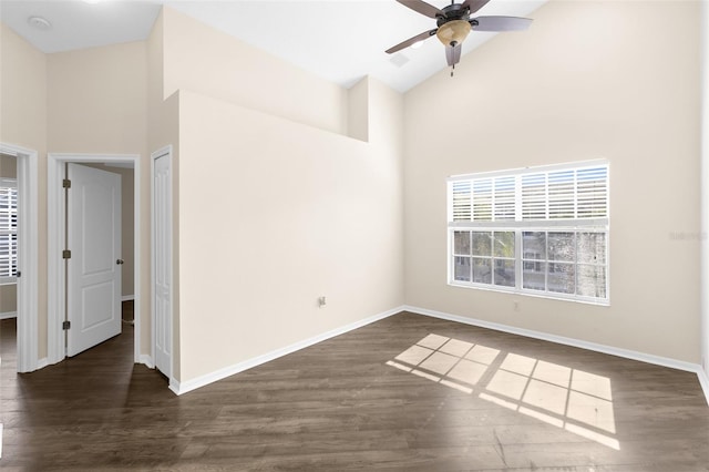 empty room featuring high vaulted ceiling, ceiling fan, baseboards, and wood finished floors
