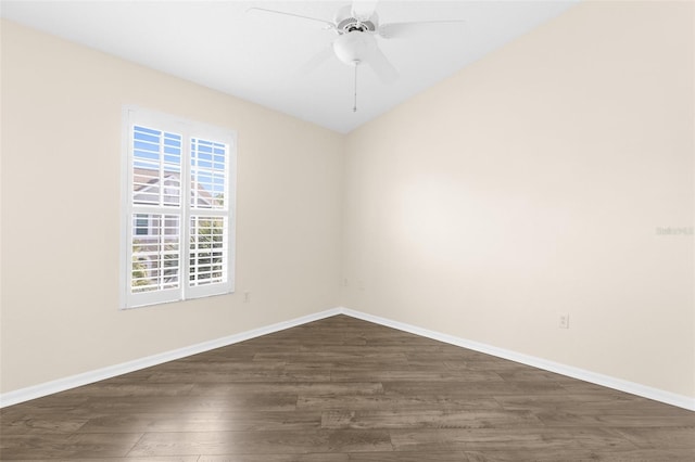 empty room featuring dark wood-style flooring, baseboards, a ceiling fan, and vaulted ceiling