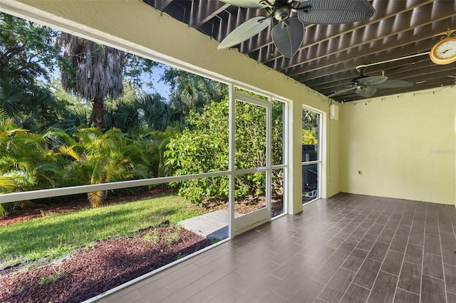 unfurnished sunroom with ceiling fan