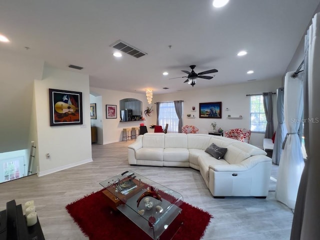 living area with healthy amount of natural light, light wood-style floors, a ceiling fan, recessed lighting, and baseboards