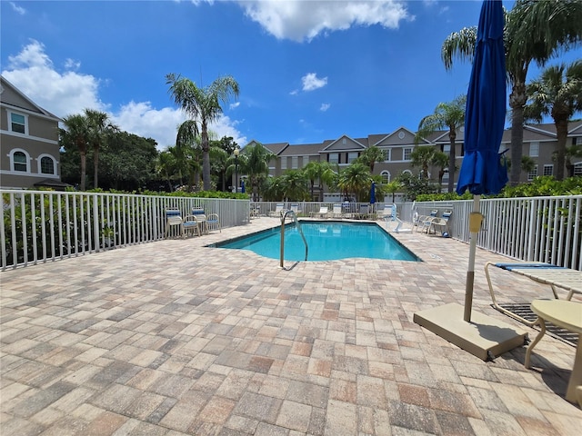 community pool with a patio area and a residential view
