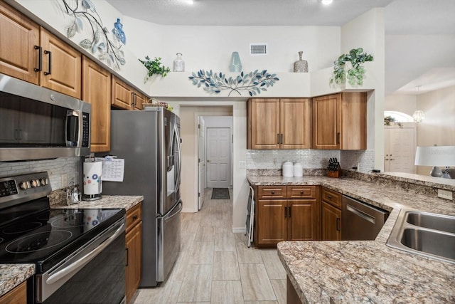 3773 E Lake Todd Dr, Hernando, FL 34442 - kitchen featuring appliances with stainless steel finishes, a sink, tasteful backsplash, and brown cabinetry
