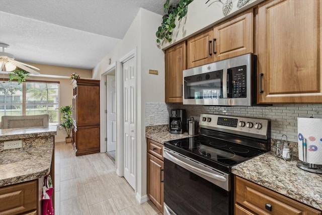 3773 E Lake Todd Dr, Hernando, FL 34442 - kitchen with appliances with stainless steel finishes, backsplash, a textured ceiling, a ceiling fan, and light stone counters