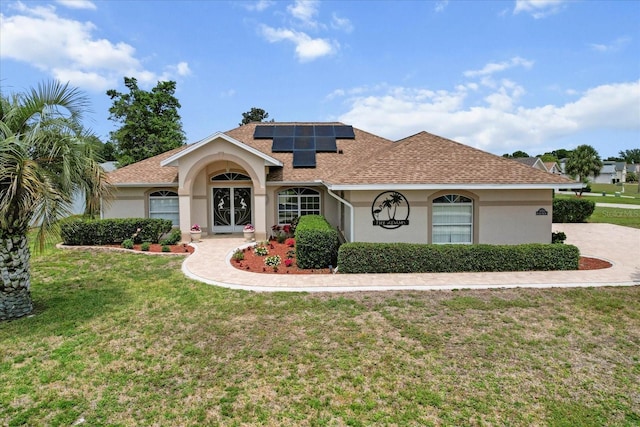3773 E Lake Todd Dr, Hernando, FL 34442 - view of front of property with stucco siding, a front lawn, solar panels, and a shingled roof