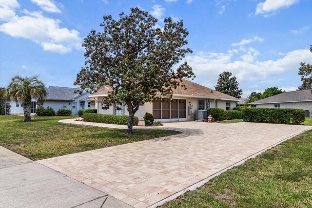 3773 E Lake Todd Dr, Hernando, FL 34442 - view of front facade featuring a front lawn, stucco siding, decorative driveway, and central air condition unit