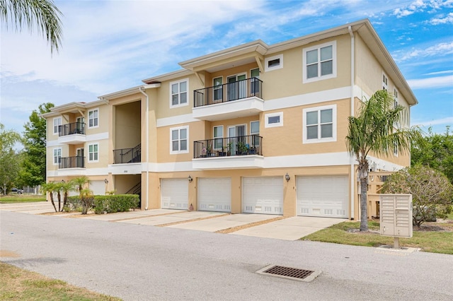 5041 Royal Palms Way Unit 203, New Port Richey, FL 34652 - view of building exterior with an attached garage and concrete driveway