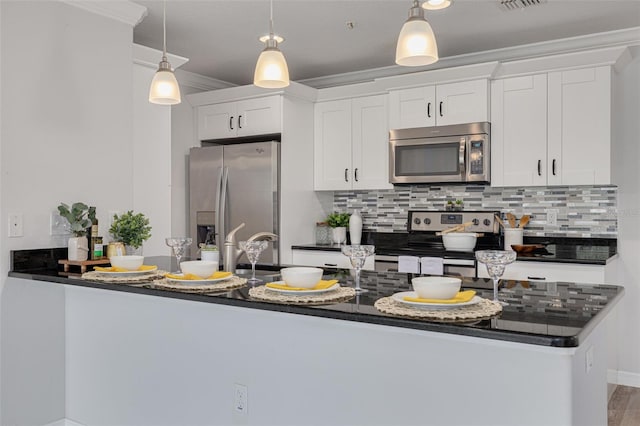 5041 Royal Palms Way Unit 203, New Port Richey, FL 34652 - kitchen with appliances with stainless steel finishes, decorative backsplash, white cabinetry, hanging light fixtures, and crown molding