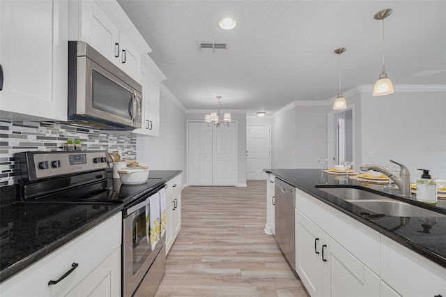 5041 Royal Palms Way Unit 203, New Port Richey, FL 34652 - kitchen featuring appliances with stainless steel finishes, a sink, ornamental molding, a chandelier, and hanging light fixtures