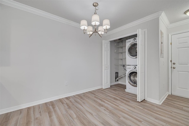 5041 Royal Palms Way Unit 203, New Port Richey, FL 34652 - washroom featuring stacked washing machine and dryer, light wood-style floors, a chandelier, and ornamental molding