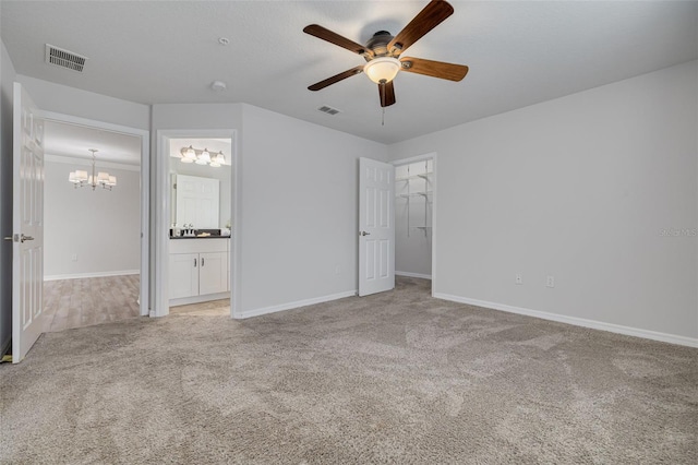 5041 Royal Palms Way Unit 203, New Port Richey, FL 34652 - unfurnished bedroom featuring a chandelier, light colored carpet, baseboards, and ensuite bath