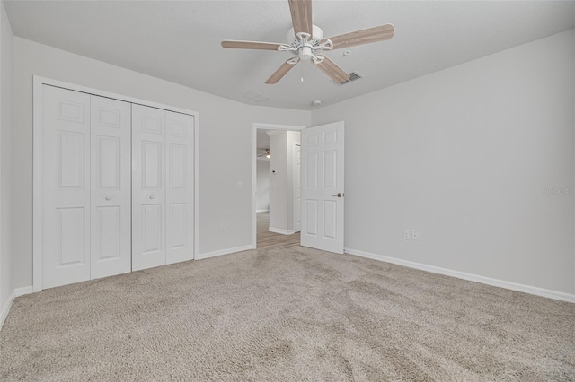 5041 Royal Palms Way Unit 203, New Port Richey, FL 34652 - unfurnished bedroom featuring carpet floors, a closet, baseboards, and a ceiling fan