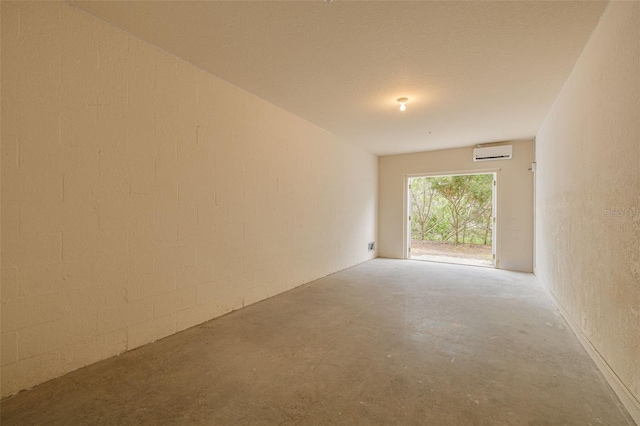5041 Royal Palms Way Unit 203, New Port Richey, FL 34652 - empty room with a wall unit AC and unfinished concrete floors