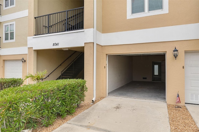 5041 Royal Palms Way Unit 203, New Port Richey, FL 34652 - view of exterior entry with stucco siding and an attached garage