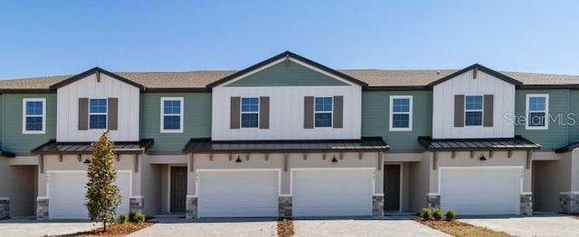 townhome / multi-family property featuring a standing seam roof, an attached garage, metal roof, and board and batten siding