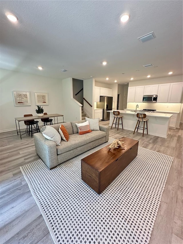 5232 Luisa Ct, Saint Cloud, FL 34771 - living room with light wood-type flooring, stairs, recessed lighting, and baseboards