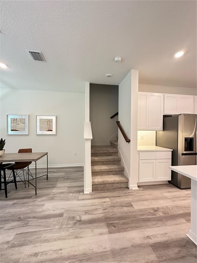 5232 Luisa Ct, Saint Cloud, FL 34771 - interior space featuring stainless steel refrigerator with ice dispenser, light wood-style floors, white cabinetry, light countertops, and recessed lighting