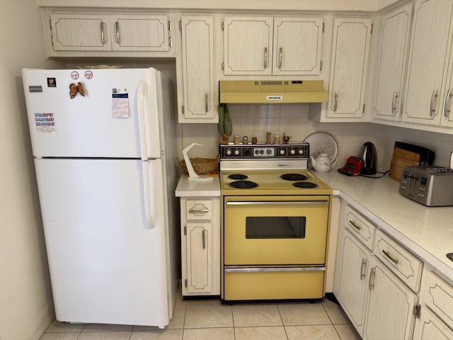 kitchen with white appliances, under cabinet range hood, light countertops, and tasteful backsplash