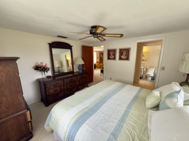 bedroom with ensuite bath, light carpet, and ceiling fan