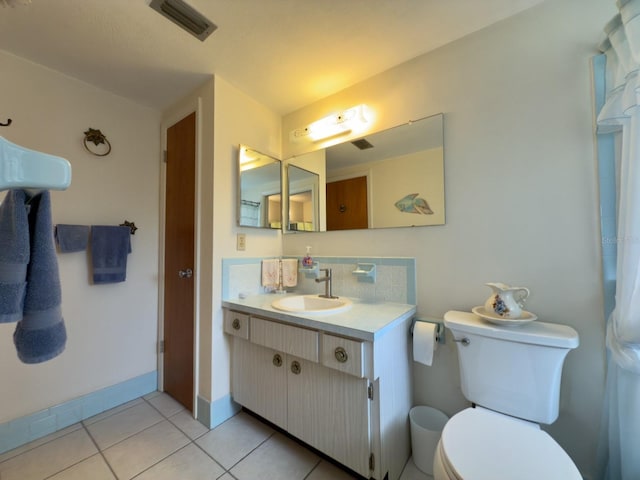 bathroom with tile patterned floors, toilet, vanity, and baseboards