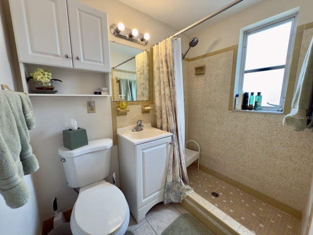 full bathroom with tiled shower, tile patterned floors, toilet, tile walls, and vanity